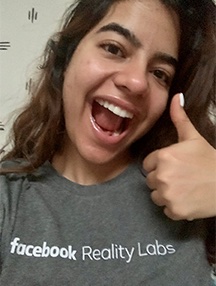 Anjali Kehmani giving the thumbs up sign with a Facebook Reality Labs t-shirt on